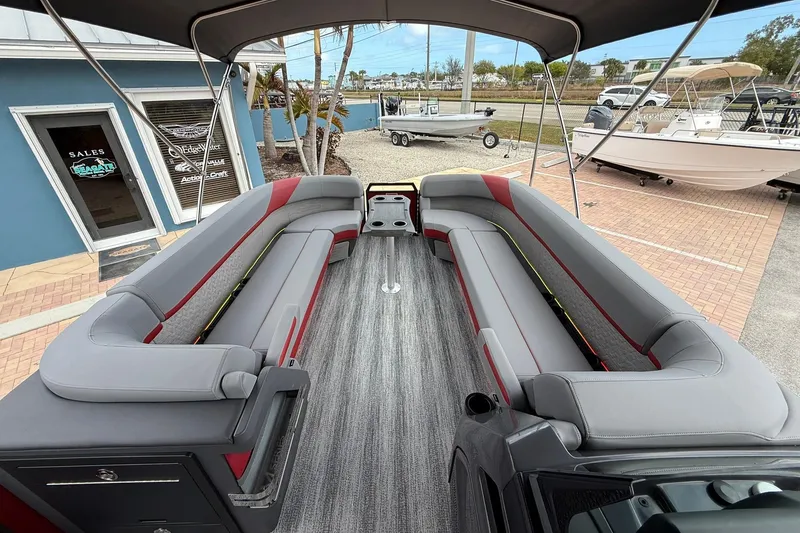 Slide: The Image of 2026 Bennington 26 M Center Swingback boat interior with gray and red seating. - 18