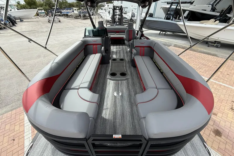Slide: The Image of 2026 Bennington 26 M Center Swingback boat interior with gray and red seating. - 20