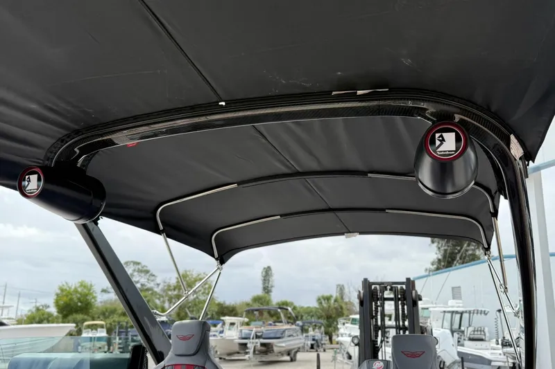 Slide: The Image of 2026 Bennington 26 M Center Swingback boat with black canopy and speakers. - 22