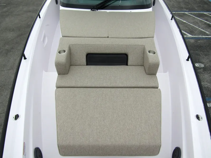 Slide: The Image of 2024 Axopar 37 Sun Top boat with beige cushioned seating and cup holders. - 18