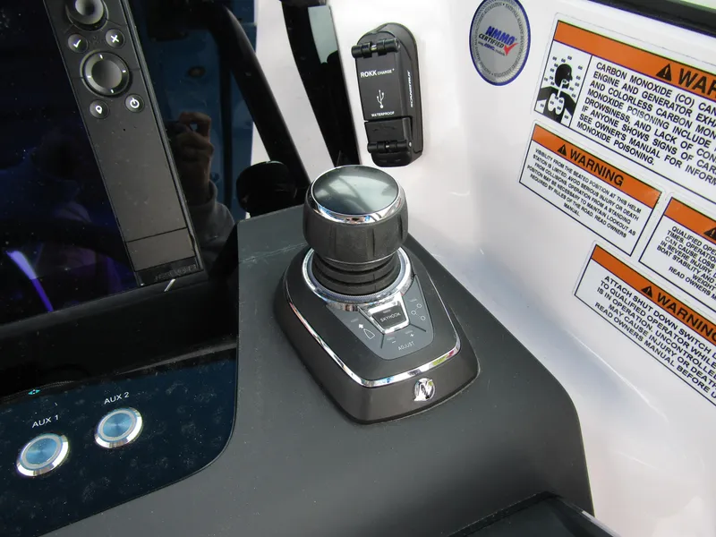 Slide: The Image of Control panel of 2024 Axopar 37 Sun Top boat with joystick and warning labels. - 28