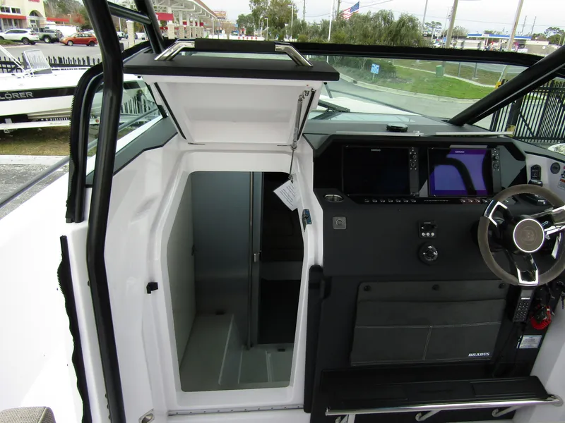 Slide: The Image of 2024 Axopar 37 Sun Top interior cockpit with open cabin door and modern dashboard. - 32