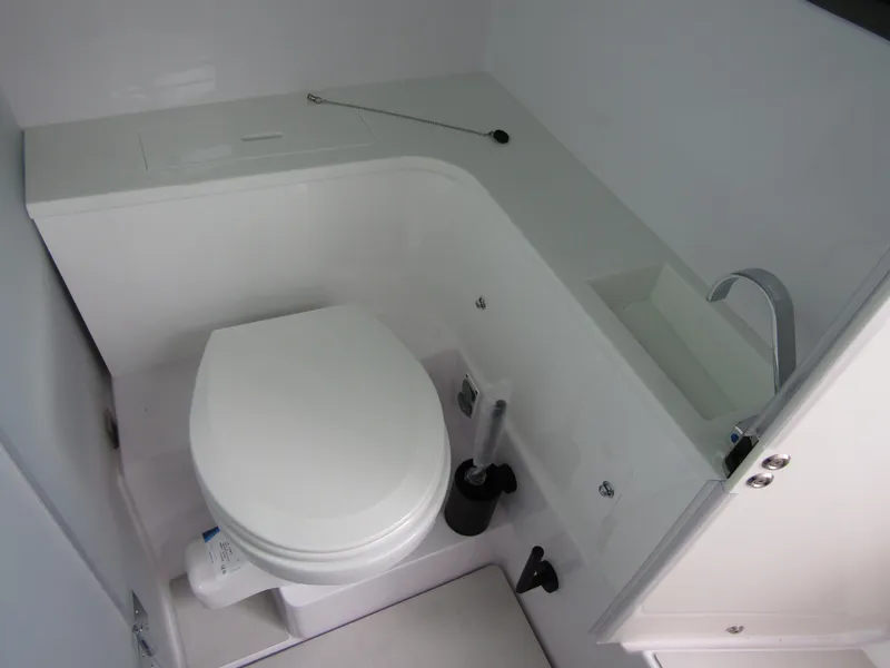 Slide: The Image of 2024 Axopar 37 Sun Top boat bathroom with modern white fixtures. - 33