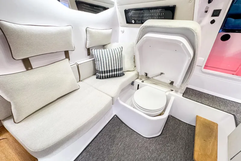 Slide: The Image of 2025 Axopar 37 Sun Top BRABUS Trim interior with seating and concealed toilet. - 32