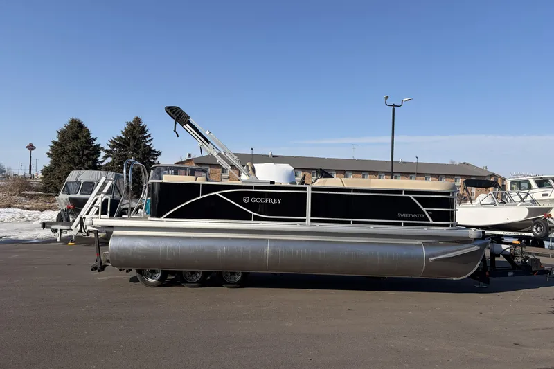 The Image of 2026 Godfrey Sweetwater 2086 C pontoon boat on trailer, parked outdoors. - 0