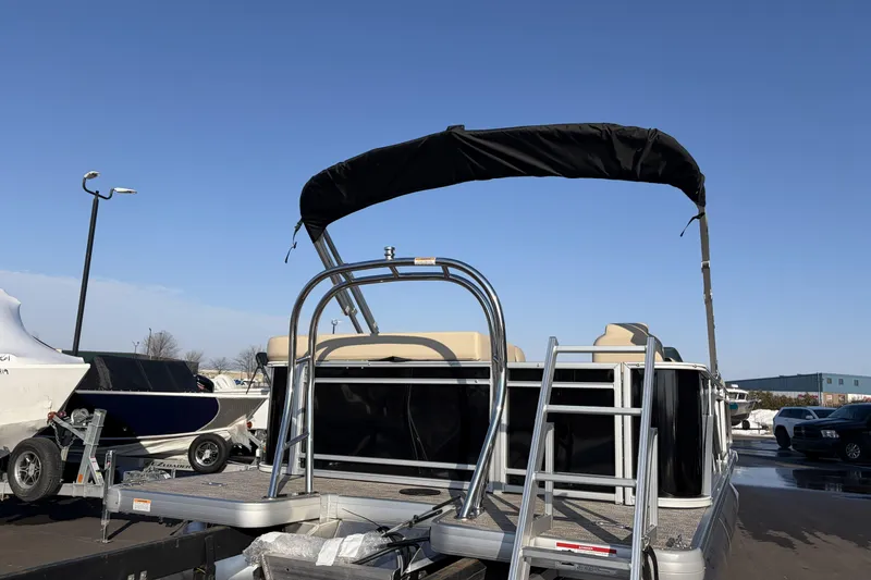 Slide: The Image of 2026 Godfrey Sweetwater 2086 C pontoon boat with canopy and ladder in a parking lot. - 5
