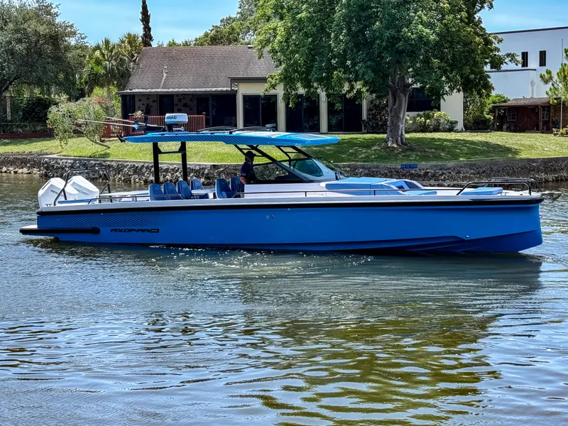 The Image of 2025 Axopar 37 Sun Top BRABUS Trim boat cruising on a serene waterway. - 4