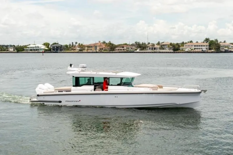 The Image of 2024 Axopar 37XC CROSS CABIN cruising on a calm waterway. - 0