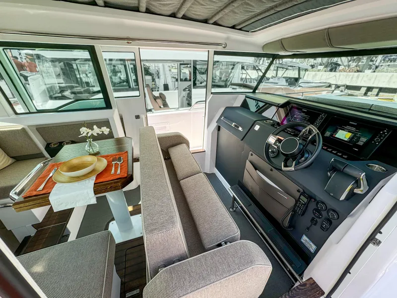 Slide: The Image of 2024 Axopar 37XC CROSS CABIN interior with modern helm, seating, and dining area. - 7