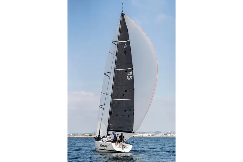 Slide: The Image of 2008 J Boats J/122 sailboat "Warrior" sailing on calm waters with cityscape background. - 51