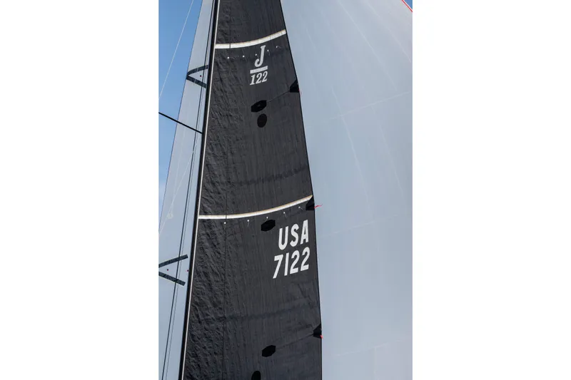 Slide: The Image of 2008 J Boats J/122 sailboat on open water with crew, blue sky, and distant mountains. - 57