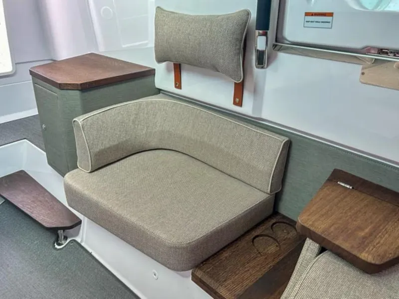Slide: The Image of 2024 Axopar 37XC CROSS CABIN interior seating with cushioned bench and wooden accents. - 14