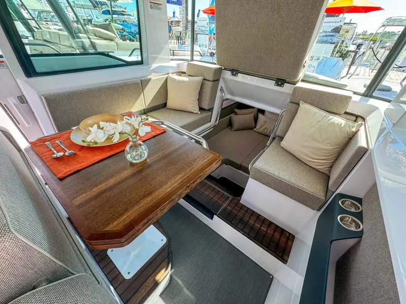 Slide: The Image of 2024 Axopar 37XC CROSS CABIN interior with cozy seating and elegant wooden table. - 8