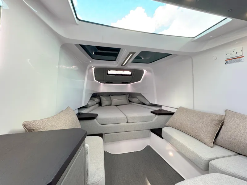 Slide: The Image of 2024 Axopar 37XC CROSS CABIN interior with modern seating and skylight. - 17