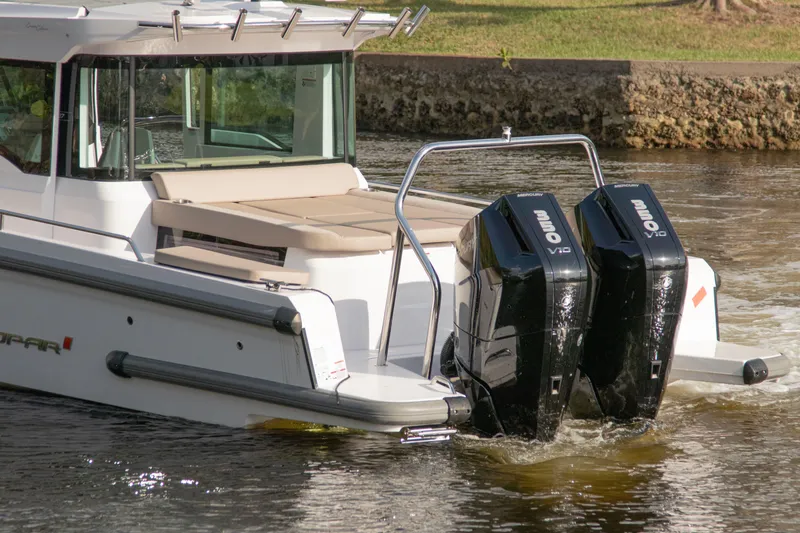 Slide: The Image of 2024 Axopar 37XC CROSS CABIN with dual outboard engines on a calm waterway. - 3