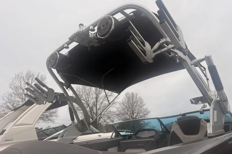 Slide: The Image of 2019 MasterCraft XStar boat with wakeboard tower and speakers, under cloudy sky. - 12