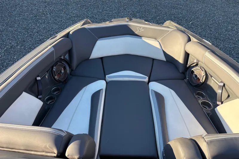 Slide: The Image of 2019 MasterCraft XStar boat interior with gray and white seating, cup holders, and speakers. - 9