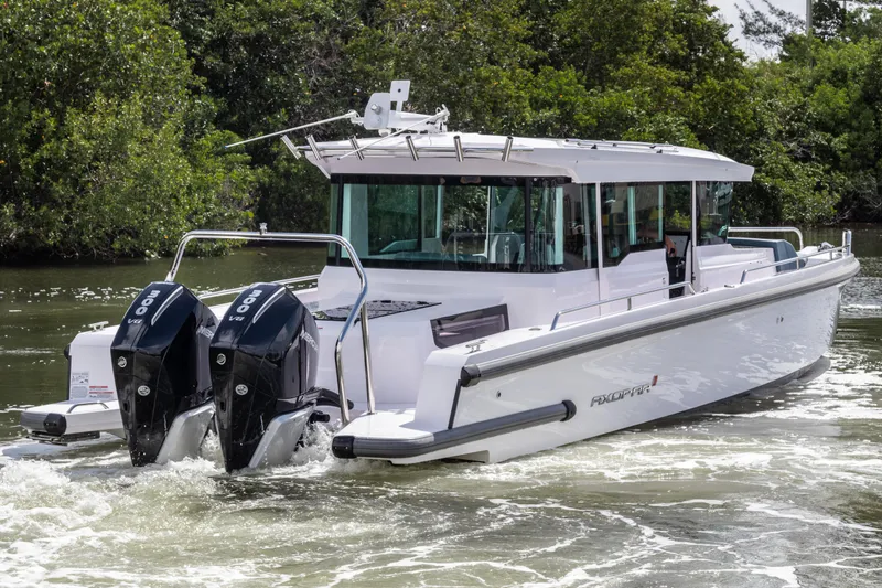 The Image of 2024 Axopar 37XC CROSS CABIN boat with dual engines cruising on water. - 1