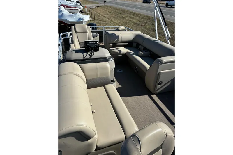 Slide: The Image of 2024 Sun Tracker Fishin' Barge 20 DLX interior with beige seating and Garmin equipment. - 58