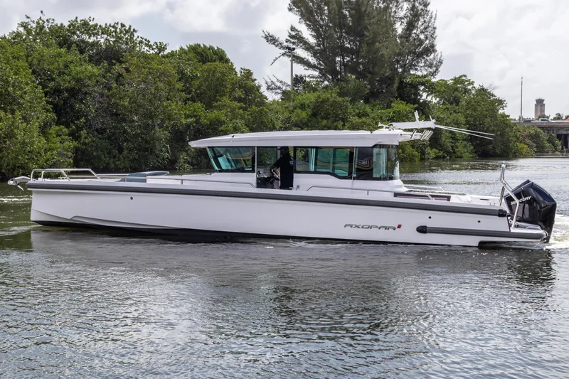 Slide: The Image of 2024 Axopar 37XC CROSS CABIN boat cruising on a calm river. - 24