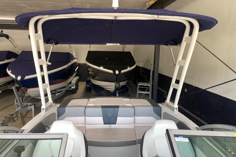Slide: The Image of 2020 Chaparral 19 SSi boat with blue canopy in storage. - 9