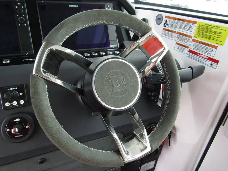 Slide: The Image of Steering wheel of 2024 Axopar 37XC CROSS CABIN boat, featuring modern controls and dashboard. - 22