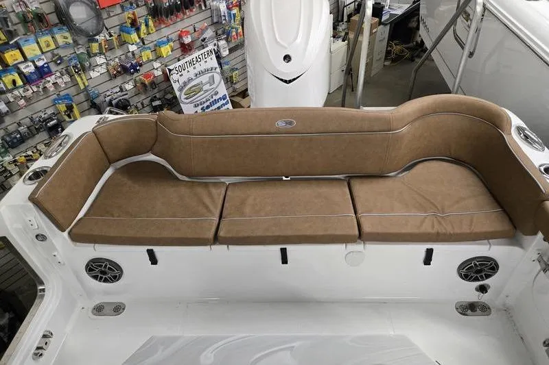 Slide: The Image of 2025 Sea Hunt Ultra 255 SE boat interior with brown cushioned seating. - 15