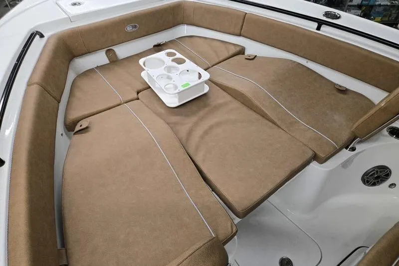 Slide: The Image of 2025 Sea Hunt Ultra 255 SE boat interior with tan cushions and cup holder tray. - 18