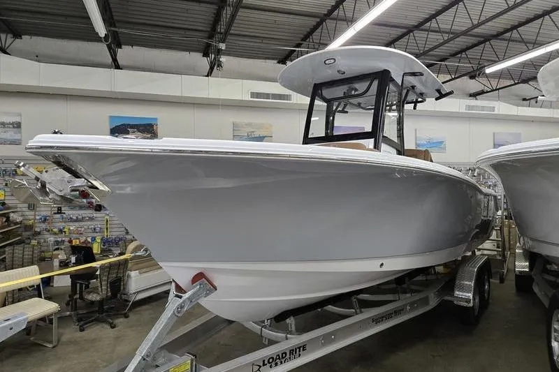 Slide: The Image of 2025 Sea Hunt Ultra 255 SE boat displayed indoors on a trailer. - 5