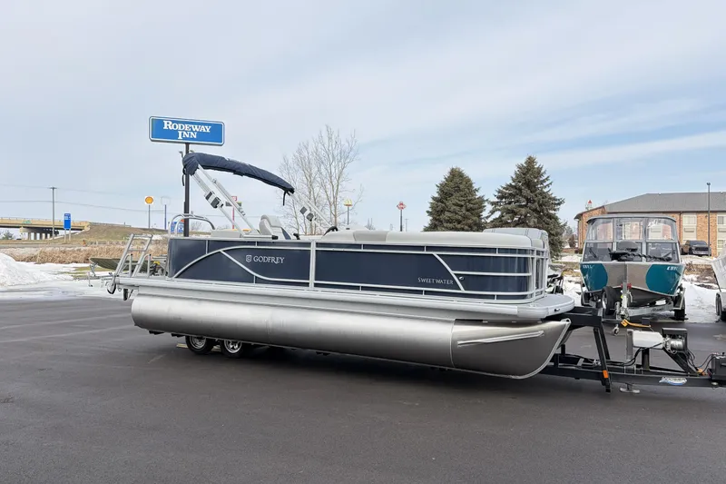 The Image of 2026 Godfrey Sweetwater 2086 C pontoon boat on trailer near Rodeway Inn. - 0