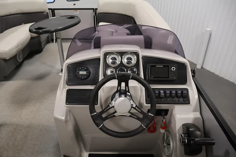 Slide: The Image of 2021 Sylvan 8522 Mirage boat dashboard with steering wheel and control panel. - 22