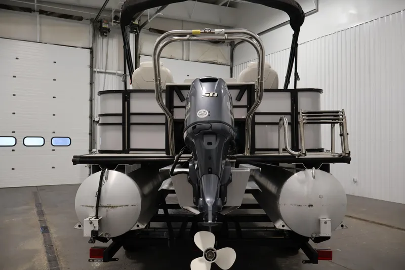 Slide: The Image of 2021 Sylvan 8522 Mirage pontoon boat with outboard motor in a garage setting. - 6