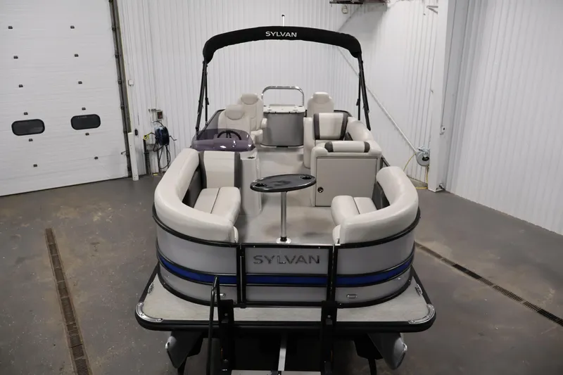 Slide: The Image of 2021 Sylvan 8522 Mirage pontoon boat in a garage, showcasing spacious seating. - 9