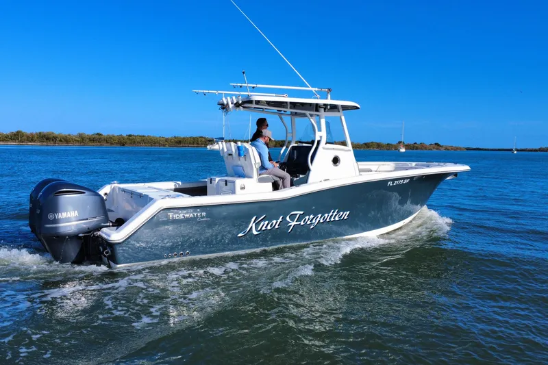 Slide: The Image of 2020 Tidewater 280 CC Adventure boat cruising on blue water with Yamaha engine. - 2