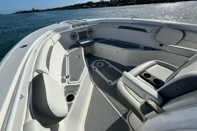 Slide: The Image of 2020 Tidewater 280 CC Adventure boat interior with seating and cup holders on a sunny day. - 22