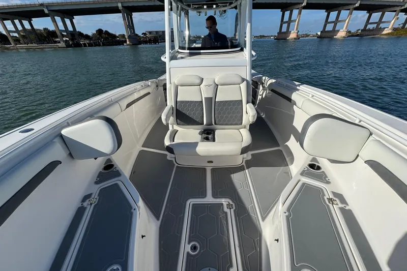 Slide: The Image of 2020 Tidewater 280 CC Adventure boat interior with seating, on a sunny day near a bridge. - 23