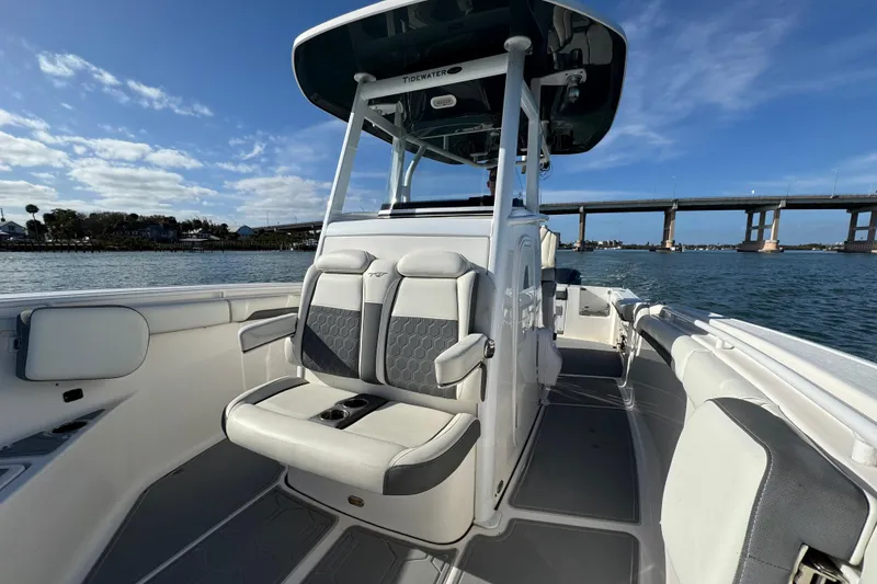 Slide: The Image of 2020 Tidewater 280 CC Adventure boat interior with seating, on a sunny day near a bridge. - 27