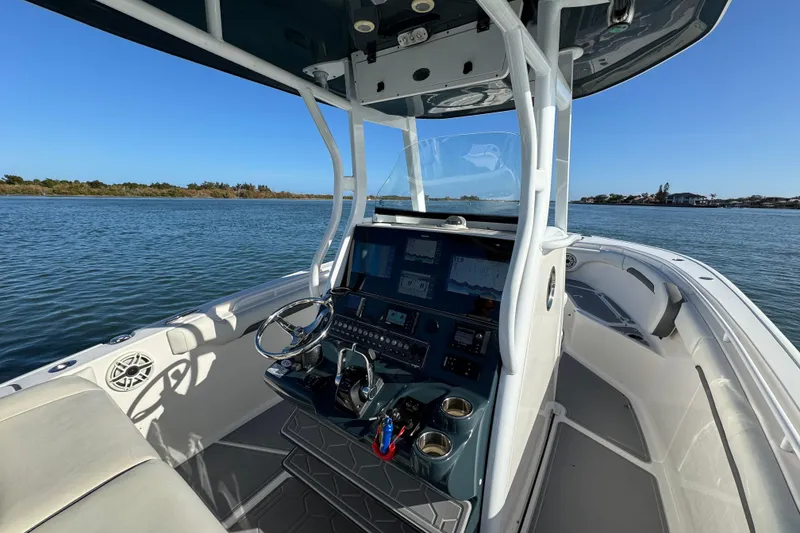 Slide: The Image of 2020 Tidewater 280 CC Adventure boat interior with modern dashboard on calm water. - 35