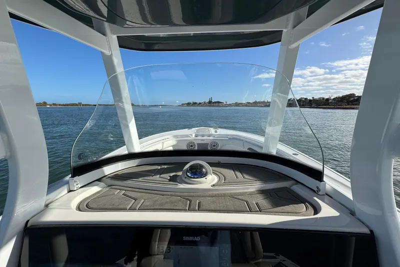 Slide: The Image of 2020 Tidewater 280 CC Adventure boat on calm water, clear sky, and scenic view. - 38