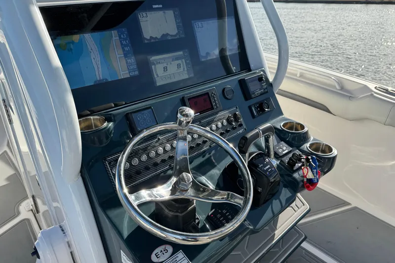 Slide: The Image of 2020 Tidewater 280 CC Adventure boat dashboard with steering wheel and navigation screens. - 47