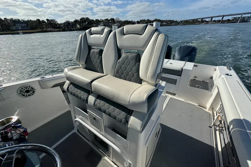 Slide: The Image of 2020 Tidewater 280 CC Adventure boat interior with dual seats on a sunny day. - 48