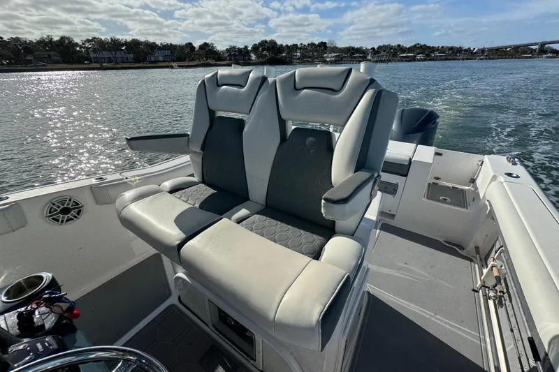Slide: The Image of 2020 Tidewater 280 CC Adventure boat interior with comfortable seating on a sunny day. - 49