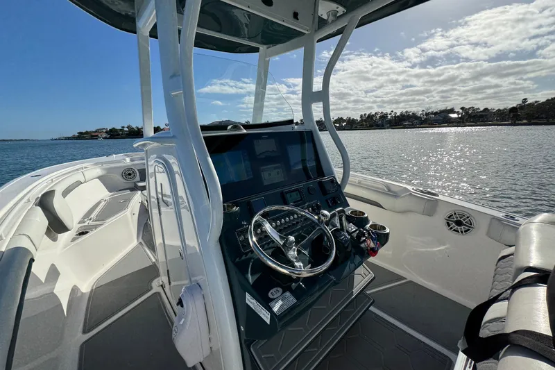 Slide: The Image of 2020 Tidewater 280 CC Adventure boat interior with steering console, on a sunny day. - 53