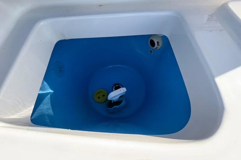 Slide: The Image of Livewell compartment in 2020 Tidewater 280 CC Adventure boat, featuring blue interior. - 56