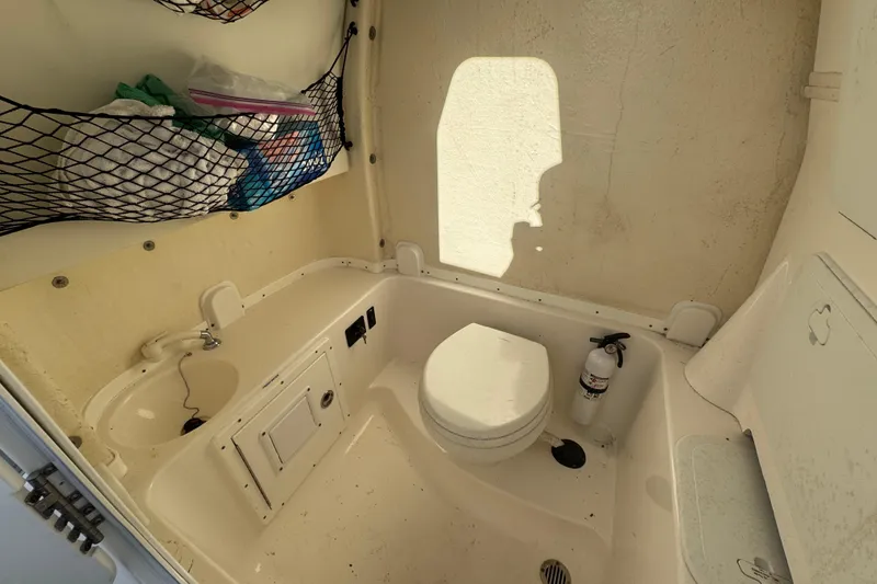 Slide: The Image of 2020 Tidewater 280 CC Adventure boat interior with toilet and storage netting. - 58