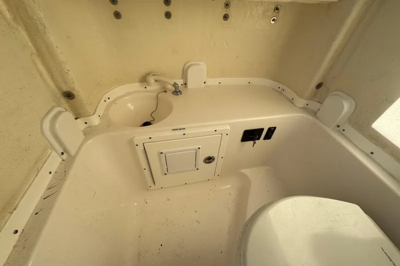 Slide: The Image of 2020 Tidewater 280 CC Adventure boat interior with sink and storage compartment. - 59