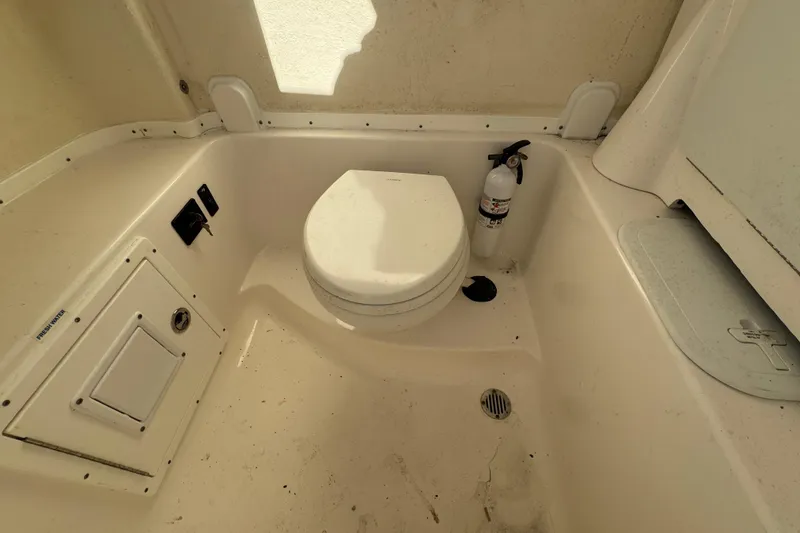Slide: The Image of 2020 Tidewater 280 CC Adventure boat interior with toilet and fire extinguisher. - 60
