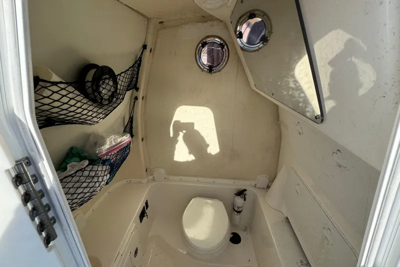 Slide: The Image of 2020 Tidewater 280 CC Adventure boat interior with storage and porthole. - 61