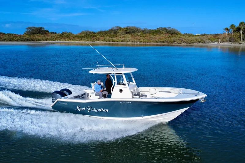 Slide: The Image of 2020 Tidewater 280 CC Adventure boat cruising on a serene blue lake. - 8
