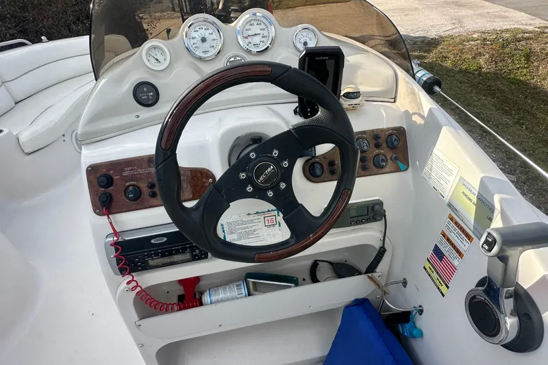 Slide: The Image of 2004 Vectra S-215 boat dashboard with steering wheel and gauges. - 10